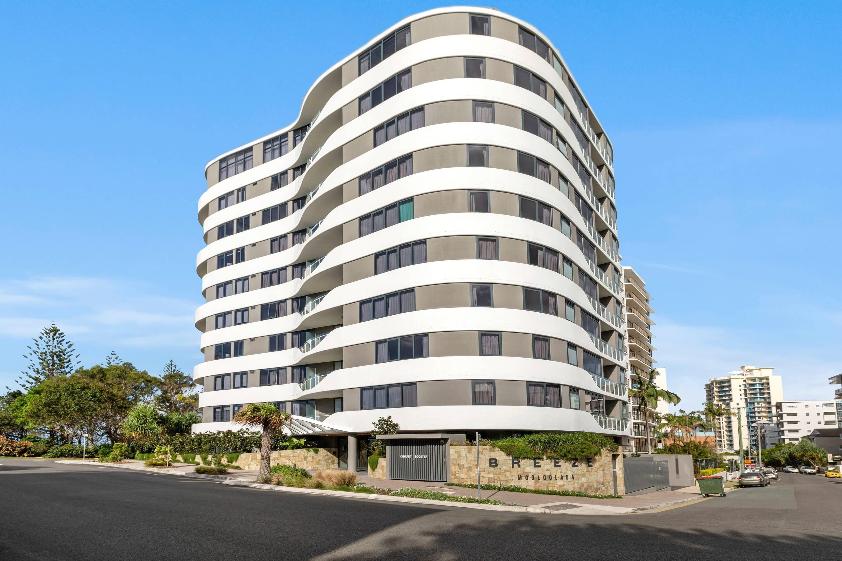 A multi-story hotel with a curved facade, balconies, and a sign indicating 'BREE' and 'MOLODLOBA.'