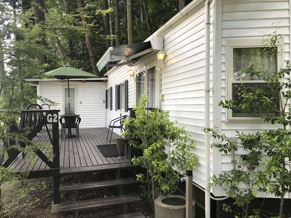 A wooden deck with outdoor furniture and a covered seating area. - Kawaguchiko country cottage Ban (Fujikawaguchiko)