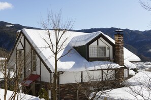 A house with a steeply pitched roof, a brick chimney, and a window with a white frame. - Kawaguchiko country cottage Ban (Fujikawaguchiko)