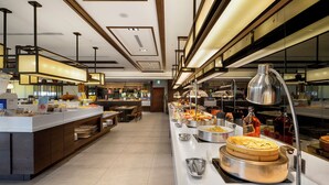 A buffet setup with various food items and utensils, a long counter, and a modern interior design. - The Walden (Yilan)