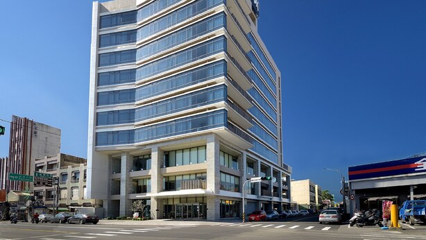 A modern multi-story building with a prominent sign at the top. - The Walden (Yilan)