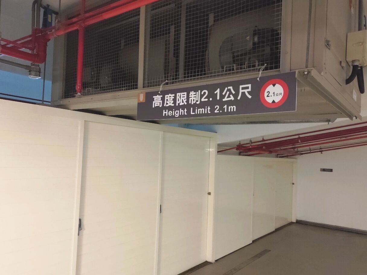A sign indicating a height limit of 2.1 meters in a building.