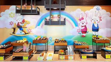 Un escaparate de pastelería con diversos pasteles y postres, que presenta un diseño caprichoso con conejos caricaturescos y un fondo de arcoíris.