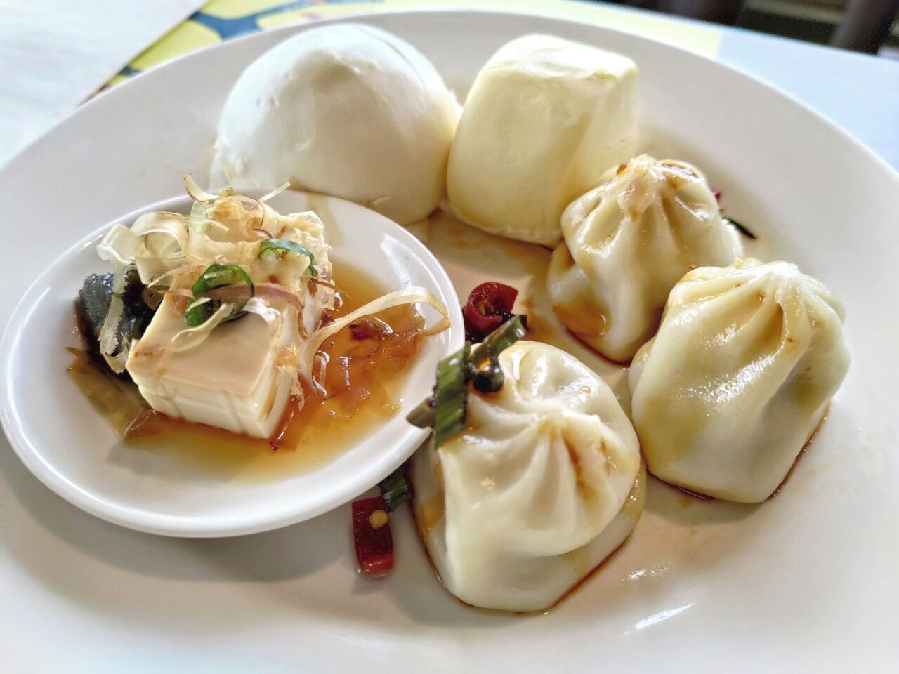 Un plato con dumplings y un tazón de tofu.