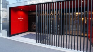 A modern hotel entrance with a red facade and black vertical bars. - Hotel Links Namba (Osaka)