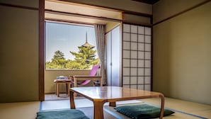 A traditional Japanese room with tatami flooring, a low wooden table, and a sliding shoji screen. - NARA Visitor Center & Inn (Nara)