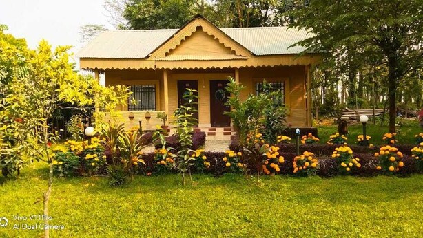 A house with a garden in front, a porch, and a small staircase leading to the entrance. - Gorkha Hamlet Resort (Sauraha)