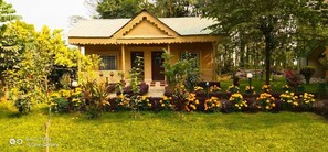 A house with a garden in front, a porch, and a small staircase leading to the entrance. - Gorkha Hamlet Resort (Sauraha)