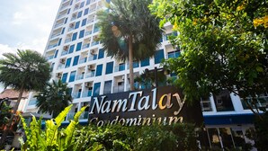 A high-rise building with a sign reading "NamTalay Condominium."