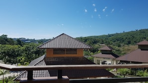 Vista de un barrio residencial con varias casas, cada una con tejado de tejas y rodeada de vegetación.