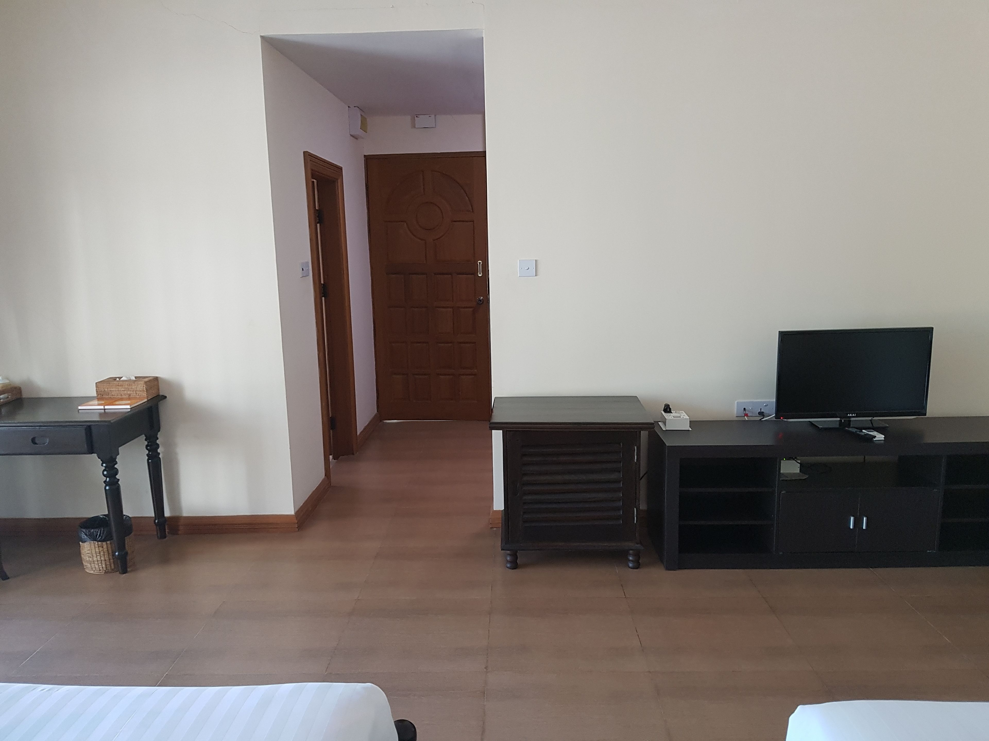 A hotel room with a bed, a desk, a television, and a wardrobe.