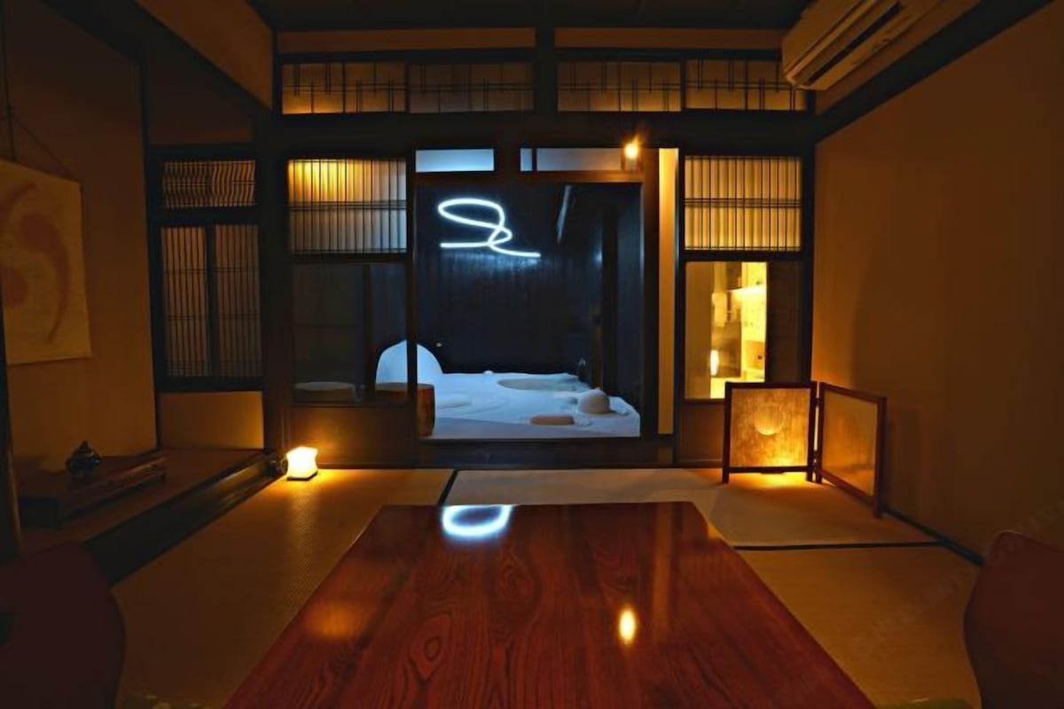 Una habitación al estilo japonés tradicional con suelo de tatami, una mesa baja de madera y puertas correderas.