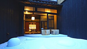 A traditional Japanese building with a wooden exterior and a snow-covered ground. - Kiraku Kyoto Aneyakoji (Kyoto)