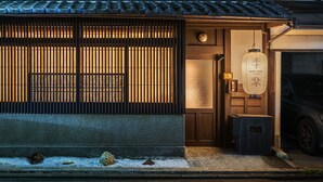 A traditional Japanese building with a wooden entrance, a lantern, and a car parked outside. - Kiraku Kyoto Aneyakoji (Kyoto)