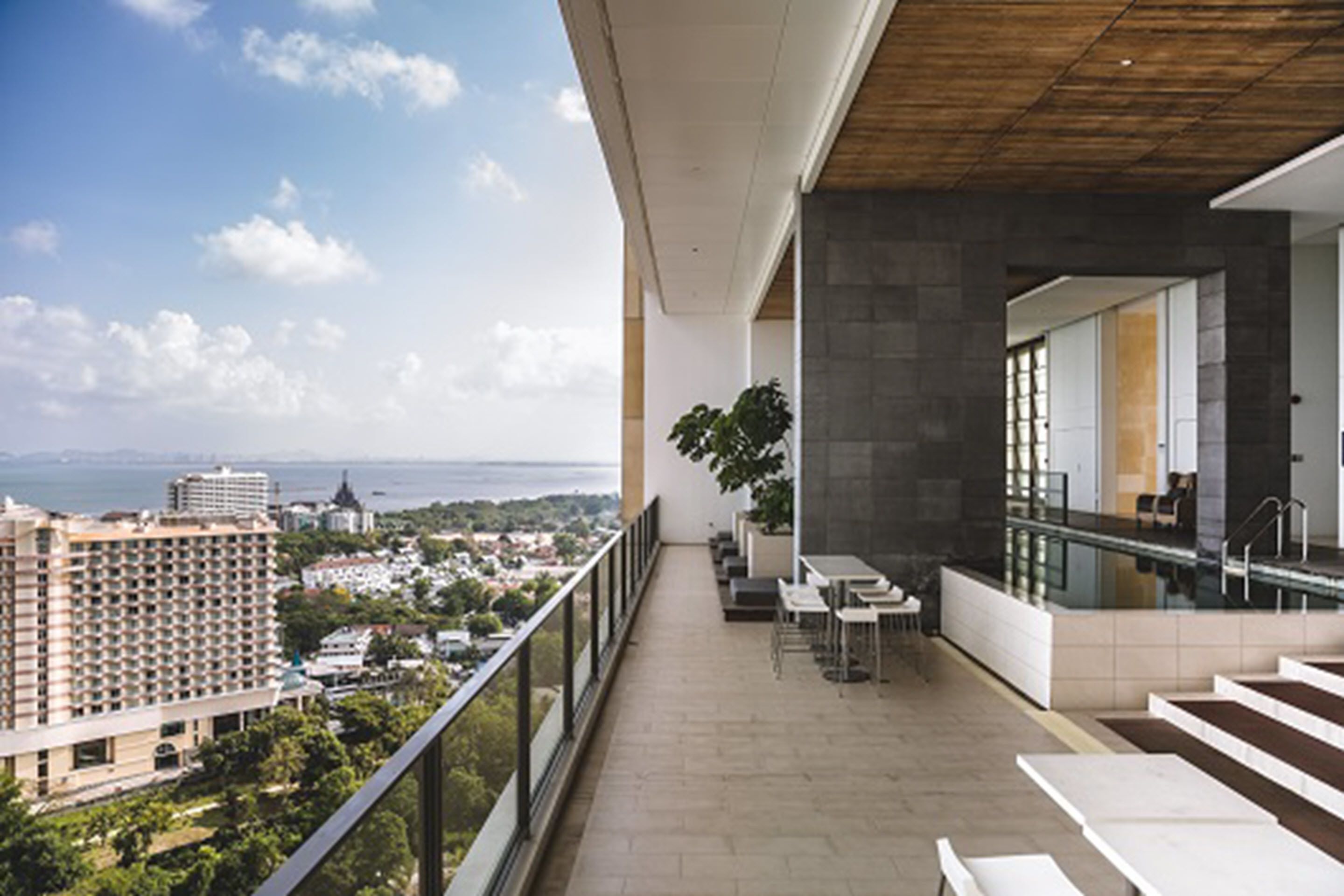 Un balcón con vistas a la ciudad, mobiliario exterior y zona de piscina.