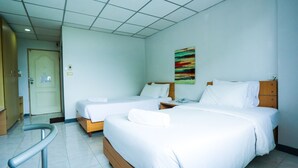A hotel room with two beds, a wooden headboard, a colorful abstract painting, a door, and a handrail. - Central Place Hotel (Rayong)