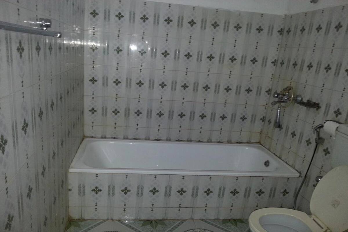 Ein Badezimmer mit Badewanne, Toilette und gefliesten Wänden.