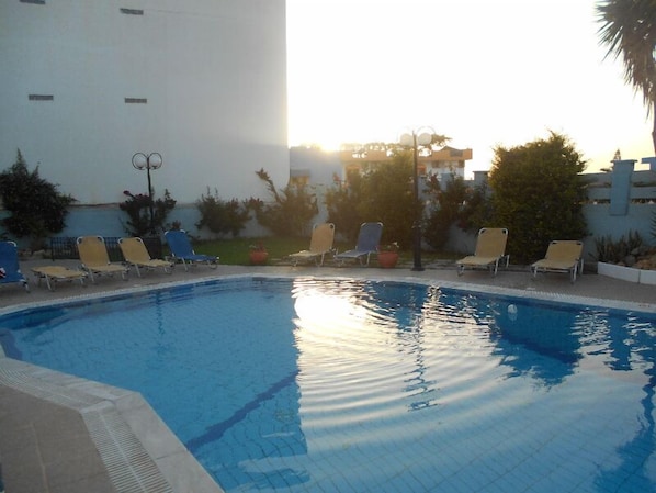 Una piscina al aire libre, tumbonas
