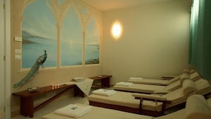 A room with a large window, a peacock mural, and three massage beds. - Hotel Residence Portoselvaggio (Nardò)