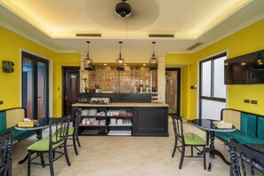 A dining area with a central island, chairs, and a bar area with shelves. - Hanoi Maro Hotel (Hanoi)