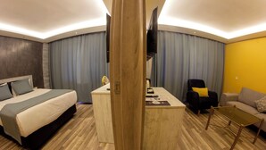 Une chambre d’hôtel moderne équipée d’un lit, d’un bureau et d’un coin salon.