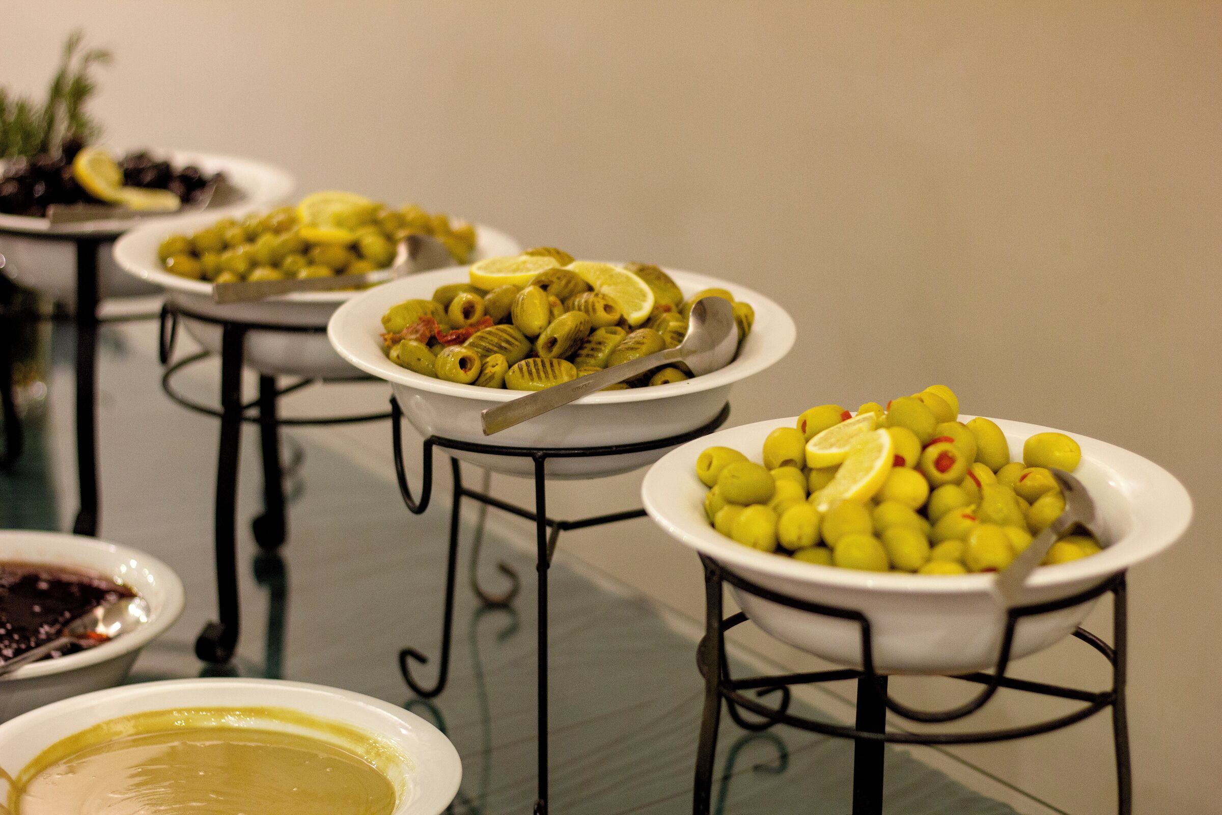 A table with various dishes, including olives and lemon slices.