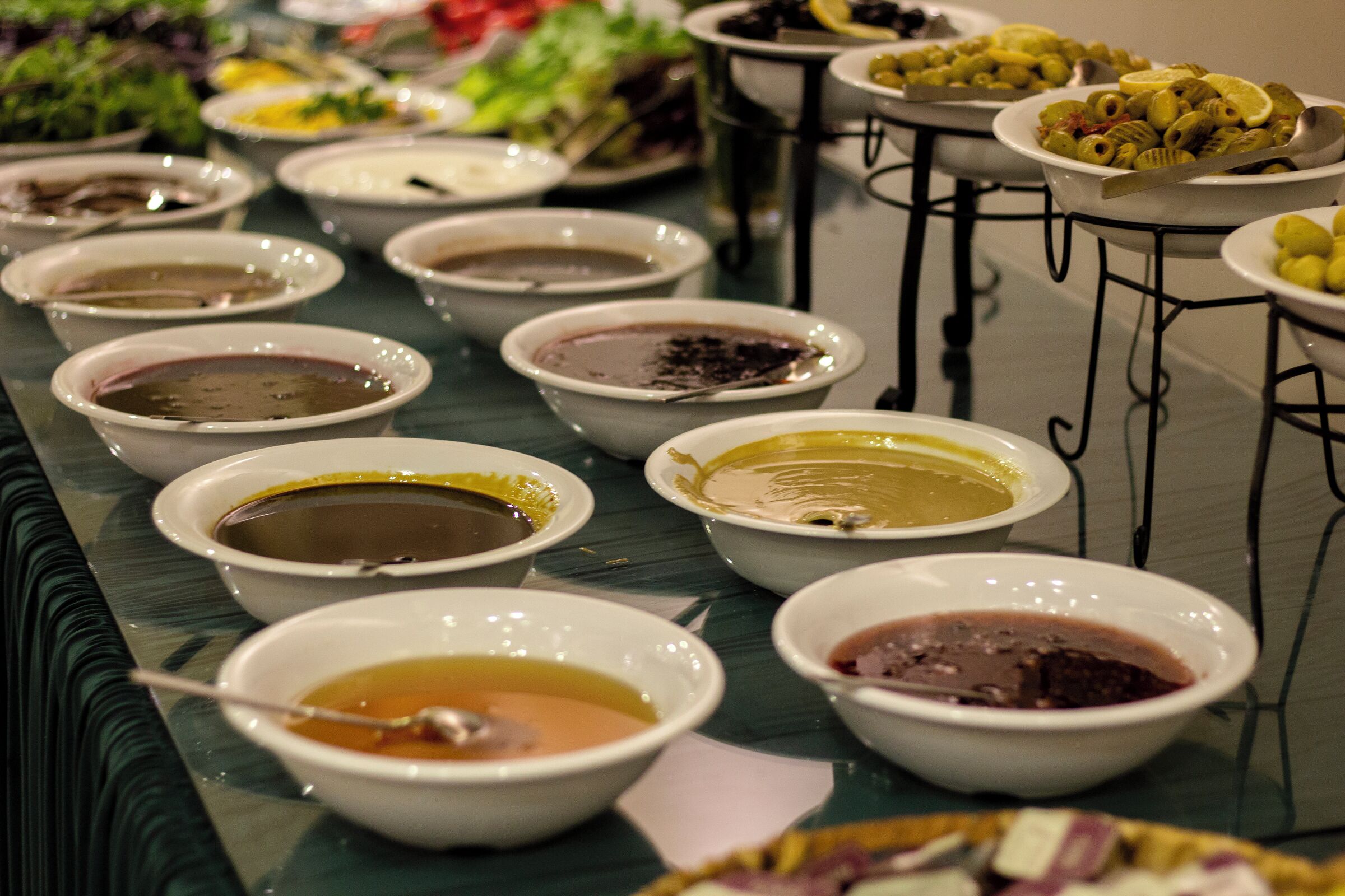 A buffet table with various dishes in bowls.