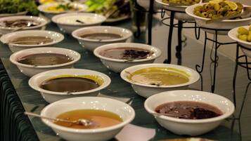 A buffet table with various dishes in bowls.