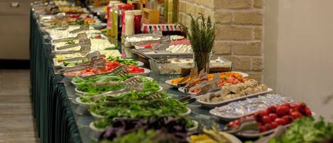 Una mesa de buffet con diversos alimentos y salsas.