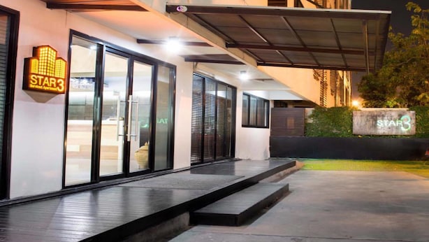Exterior de un hotel moderno con un letrero 'STAR3', puertas de cristal grandes y un área exterior cubierta.