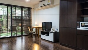 Una sala de estar moderna con un televisor de pantalla plana, una cafetera y un microondas.