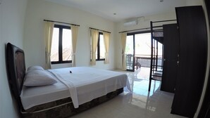 A bedroom with a bed, two windows with curtains, a balcony, and a door. - Bali Fab Dive Center - Hostel (Karangasem)