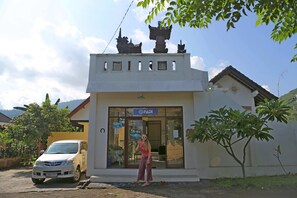 A building with a sign reading "PADI" and a car parked in front. - Bali Fab Dive Center - Hostel (Karangasem)