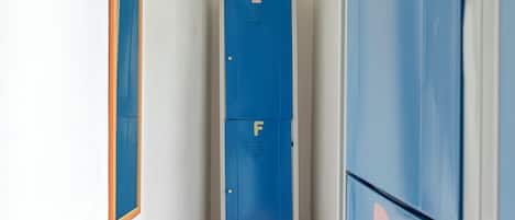 A narrow hallway with lockers labeled E, F, and D.