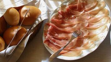 A plate of prosciutto and eggs on a table.