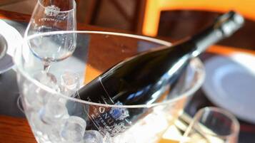 Una botella de vino en un cuenco de vidrio sobre una mesa.