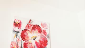 A white ceiling with a textured light fixture and a floral painting below.