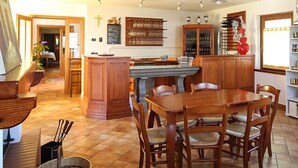 Une cuisine spacieuse avec des meubles en bois, une table à manger et des chaises. On y trouve également un grand îlot central doté d’un évier et d’un plan de travail.