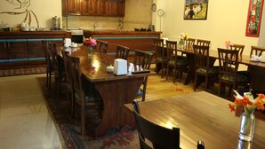 A spacious kitchen with wooden cabinets, a central island, and a dining area with wooden tables and chairs. - Konya Dervish Hotel (Konya)