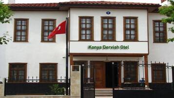 A building with a sign reading "Konya Derwish Otel" and a red flag.