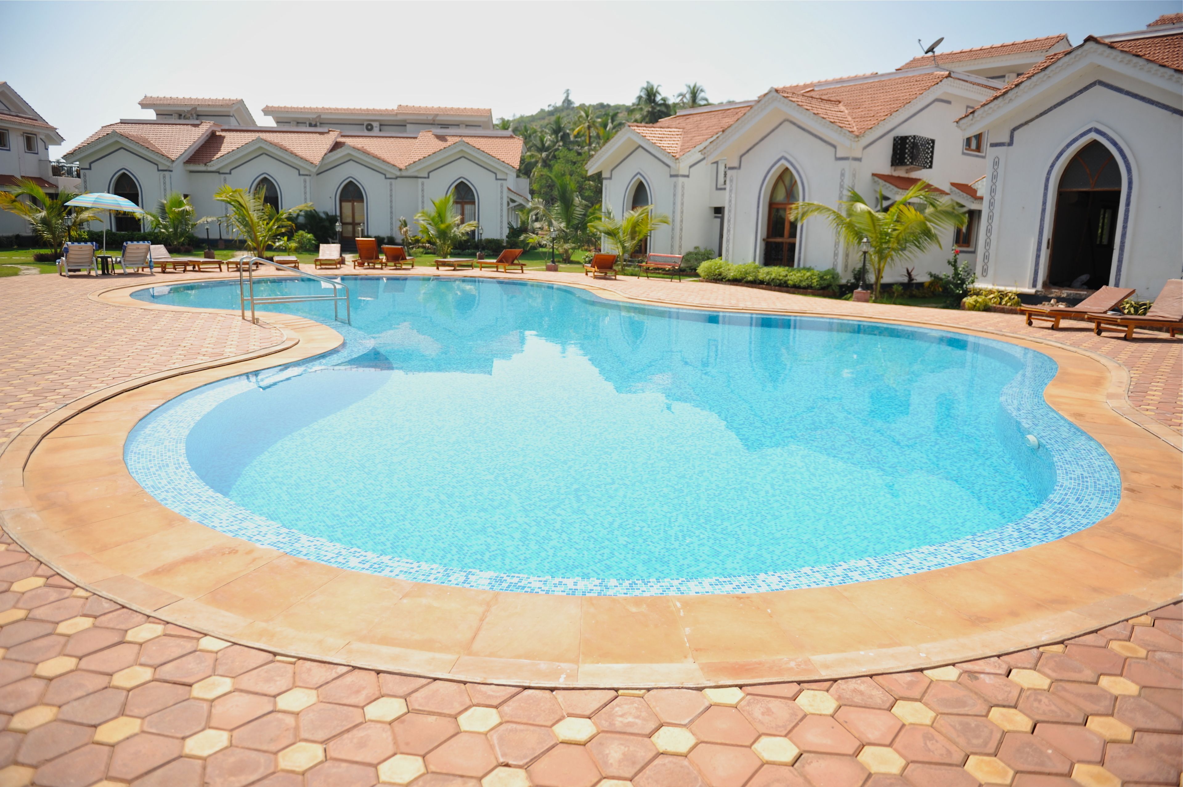 Una piscina al aire libre, sillones reclinables de piscina