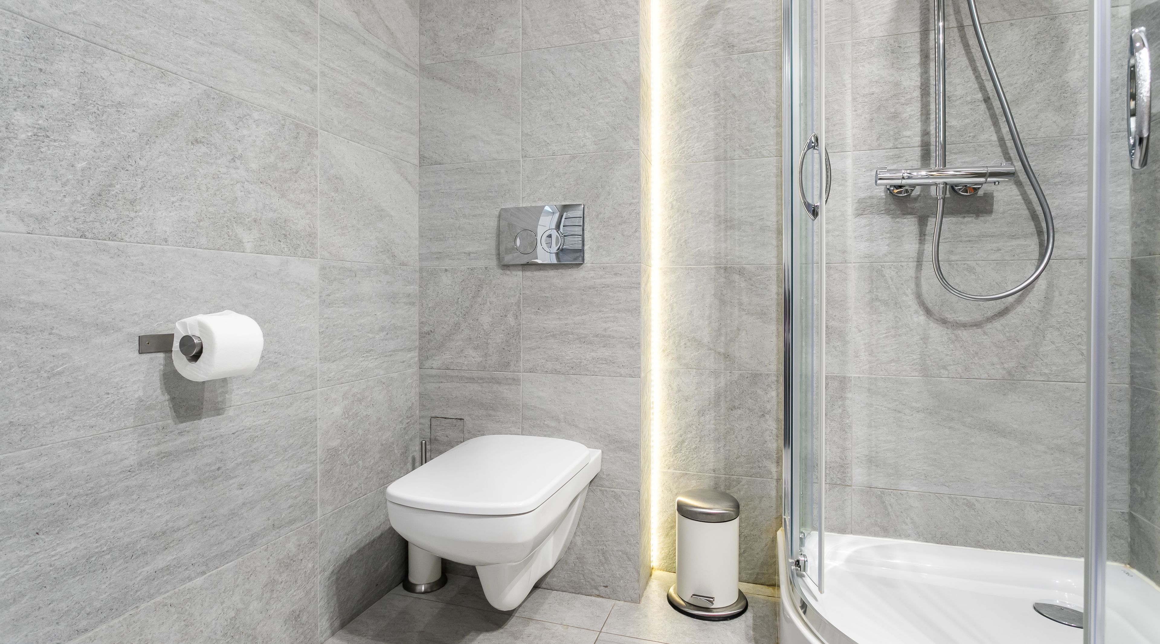 A modern bathroom with a toilet, bidet, and shower.