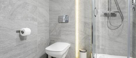 A modern bathroom with a toilet, bidet, and shower.