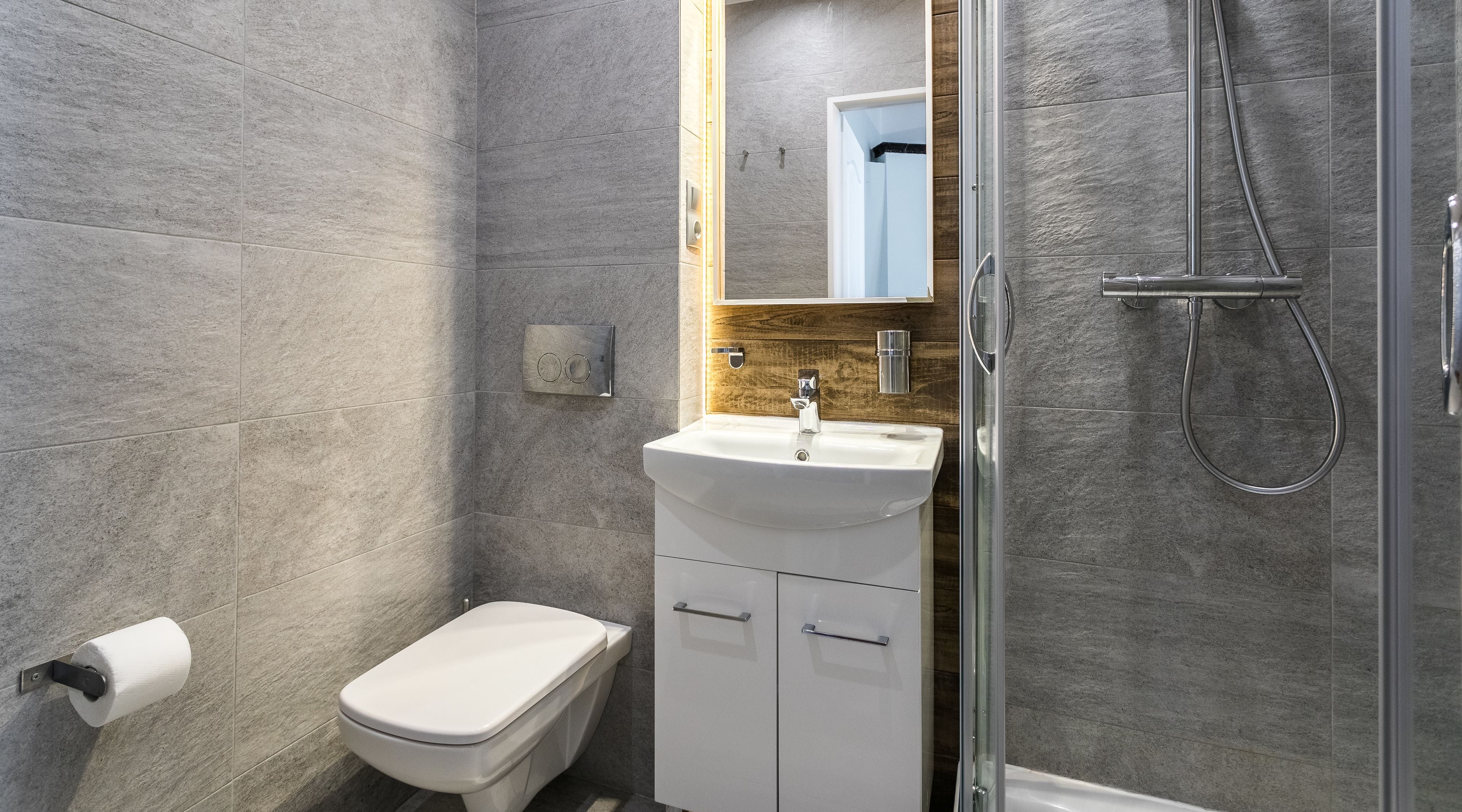 A modern bathroom with a toilet, sink, and shower.