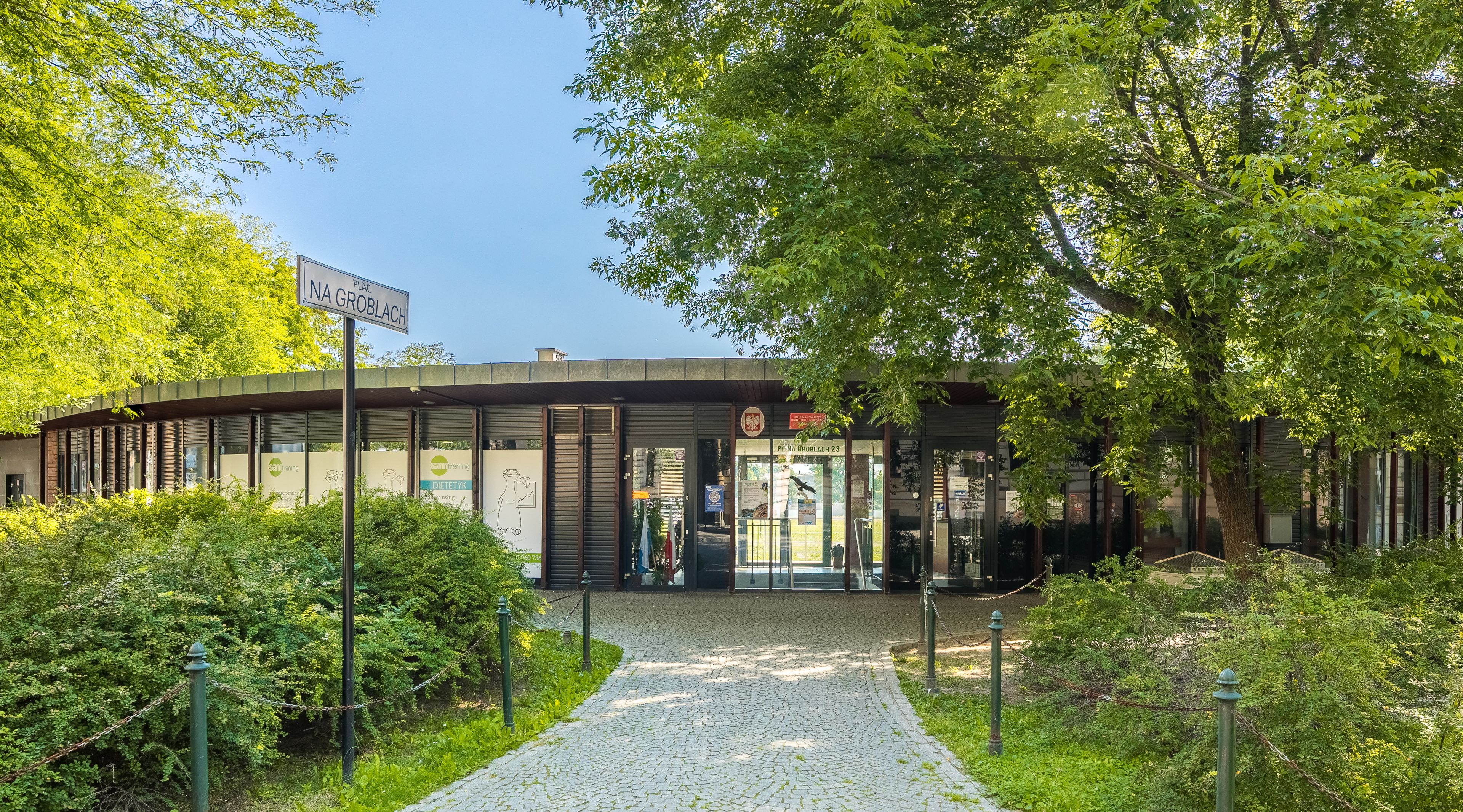 A building with a sign reading "NA GROBLACH" and a glass door entrance.