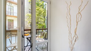 A room with a view of a courtyard, a table with chairs, and a wall with abstract art. - Old Town Residence BIS (Kraków)