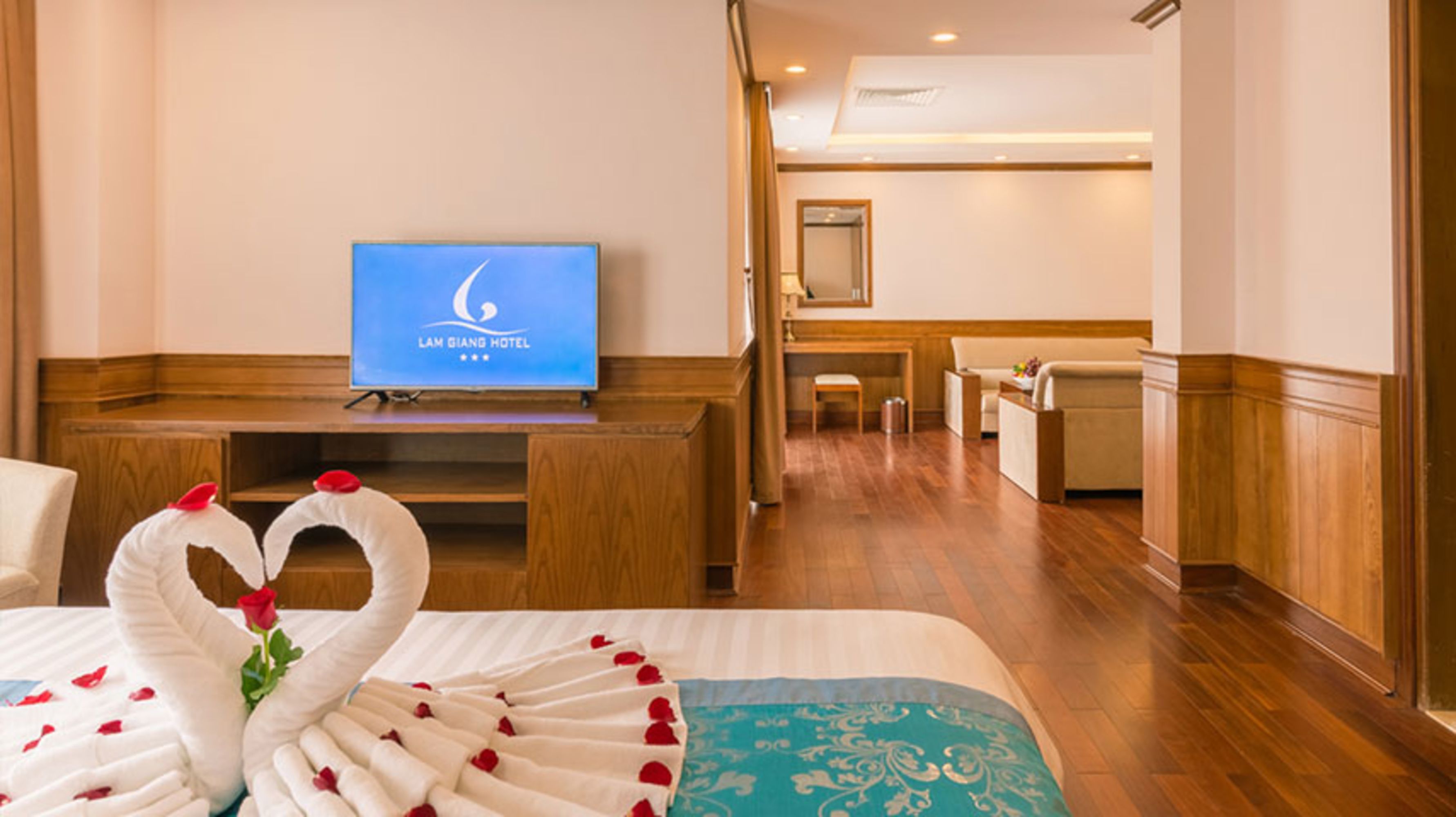 A hotel room with a bed, a TV, and a desk.