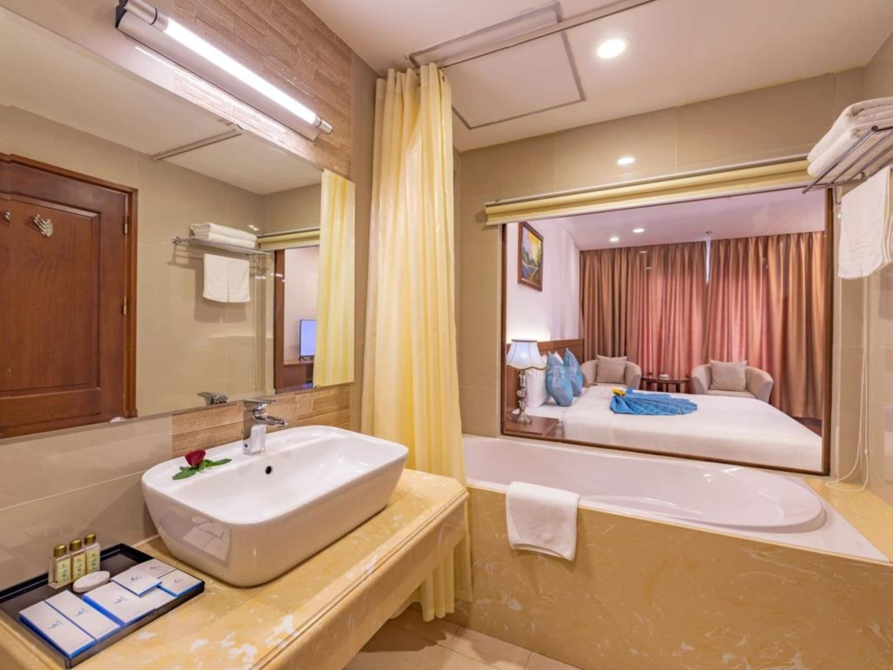A bathroom with a large sink, mirror, and bathtub.