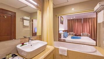 A bathroom with a large sink, mirror, and bathtub.