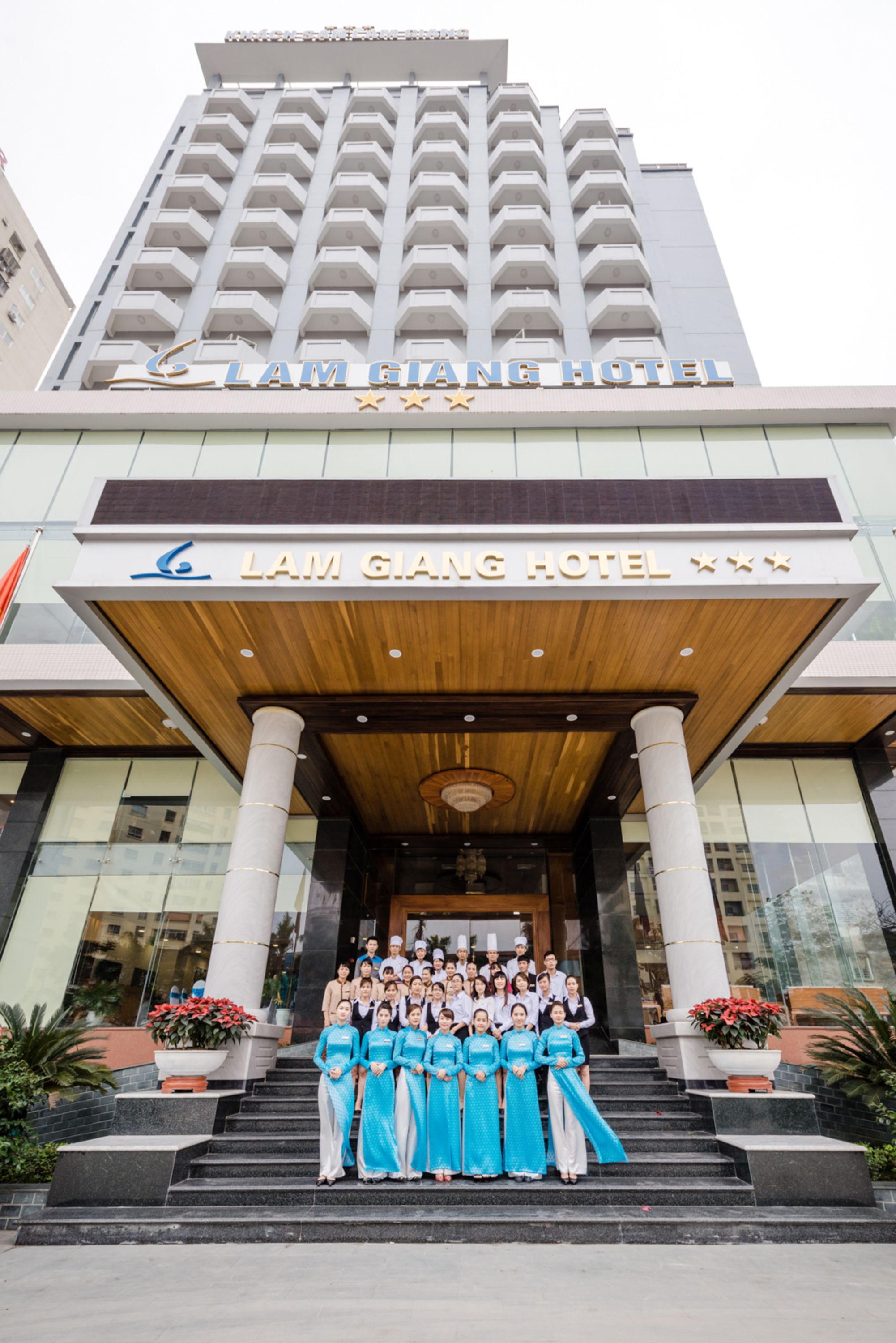 Ingresso di un hotel con un gruppo di persone in abiti tradizionali.